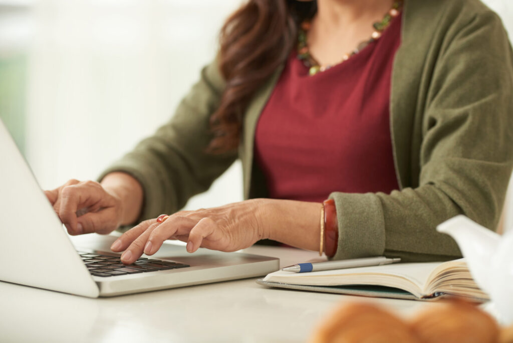 Woman working on a laptop at a table at home