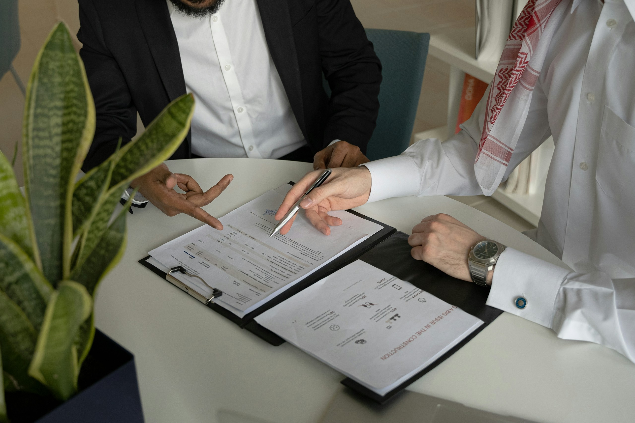 Two people reviewing a wage determination and its fringe benefit schedule before pricing a bid