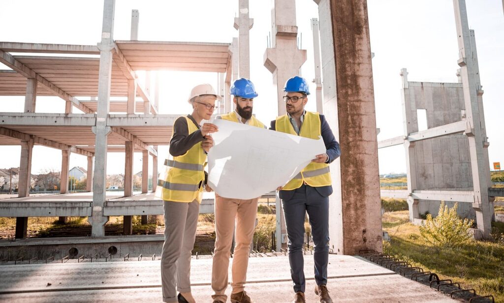 Construction team reviewing plans on a job site, where field employees count differently toward the principal office