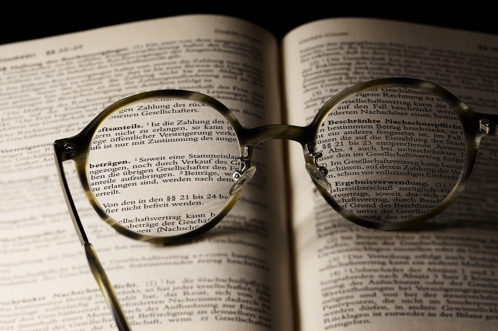 Reading glasses on an open book, a reminder that contract type hides in the solicitation text rather than the headline