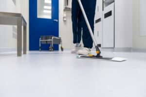 Cleaner mopping a corridor floor, the kind of federal custodial work covered by the Service Contract Act