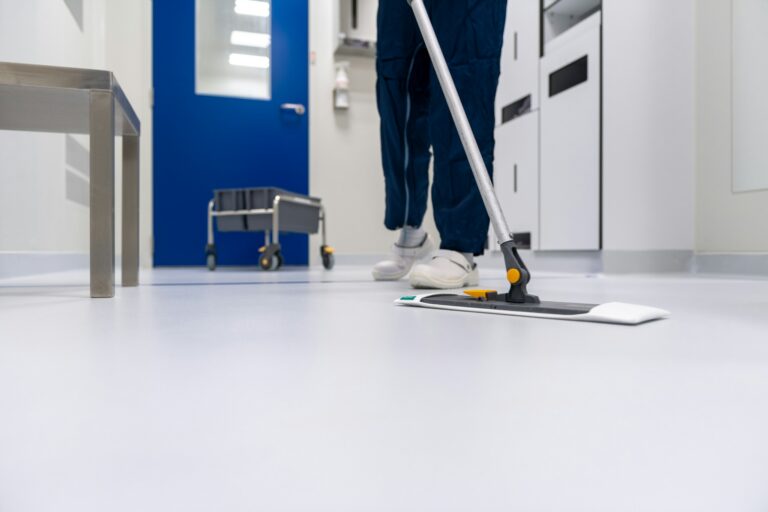 Cleaner mopping a corridor floor, the kind of federal custodial work covered by the Service Contract Act