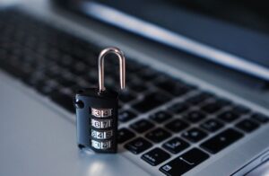 Padlock resting on a laptop keyboard, a symbol of protecting Federal Contract Information