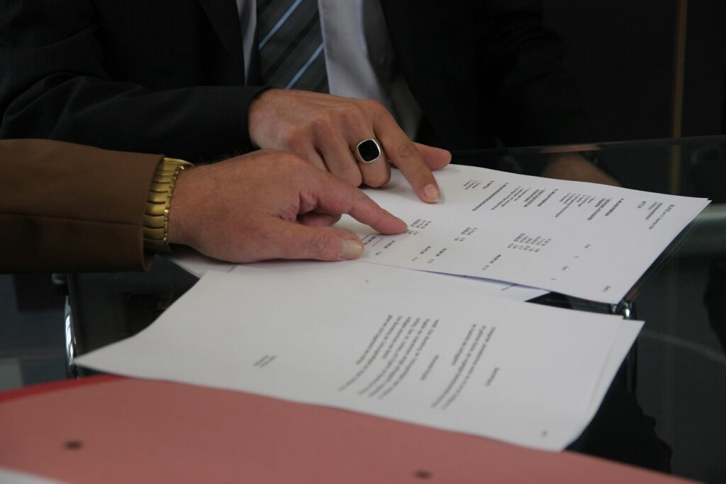 Two professionals reviewing the terms of a teaming agreement before signing