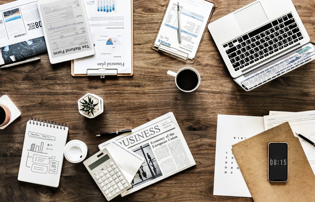 Desk with laptop and business documents used to prepare an 8(a) certification application