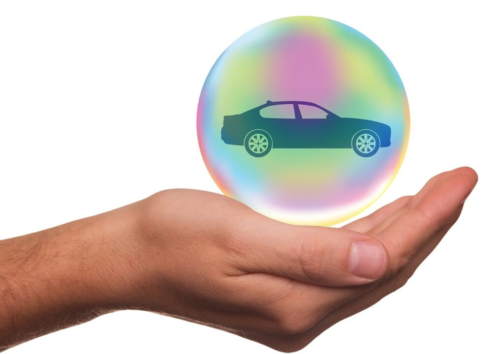 Hand holding a car in a protective bubble, representing auto insurance for government courier contracts