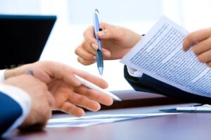 Small business owner signing 8(a) certification application documents
