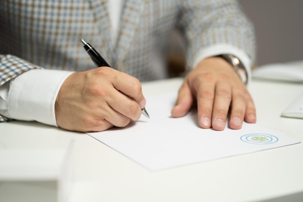 Contractor marking up a solicitation document with a pen, checking the clause list before bidding a set-aside