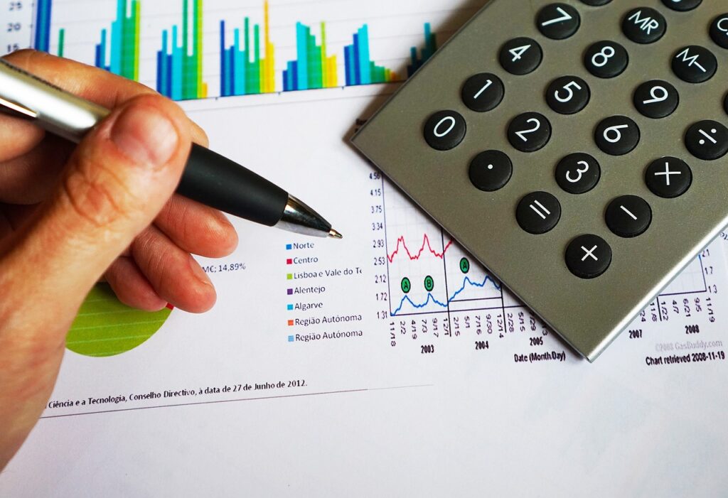 Pen and calculator over cost charts while pricing government courier contracts