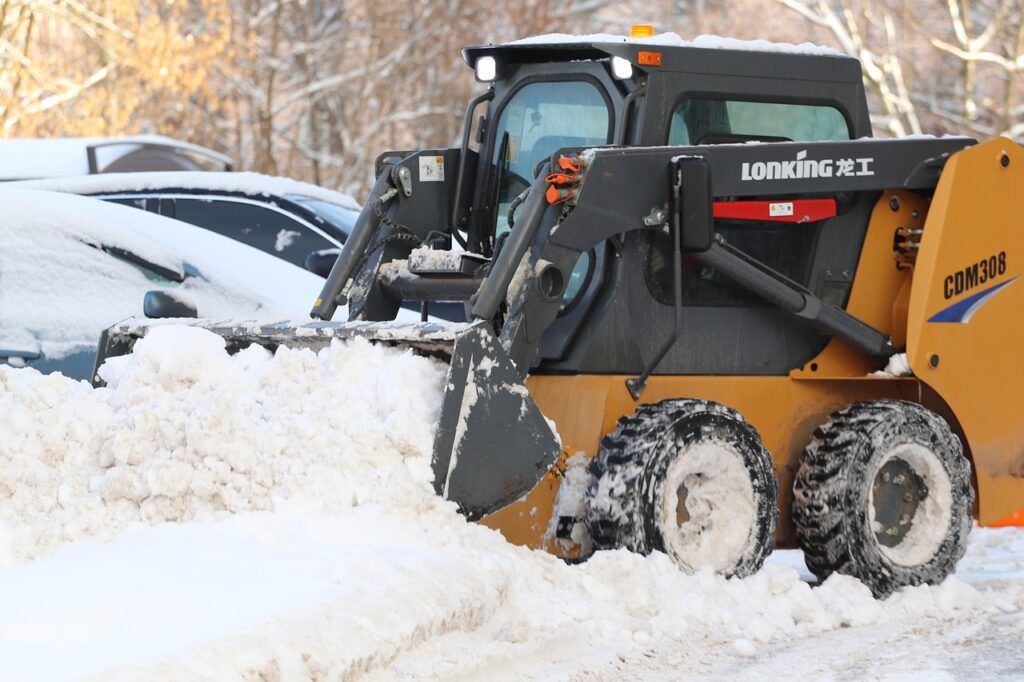 Skid steer loader clearing snow from a parking lot