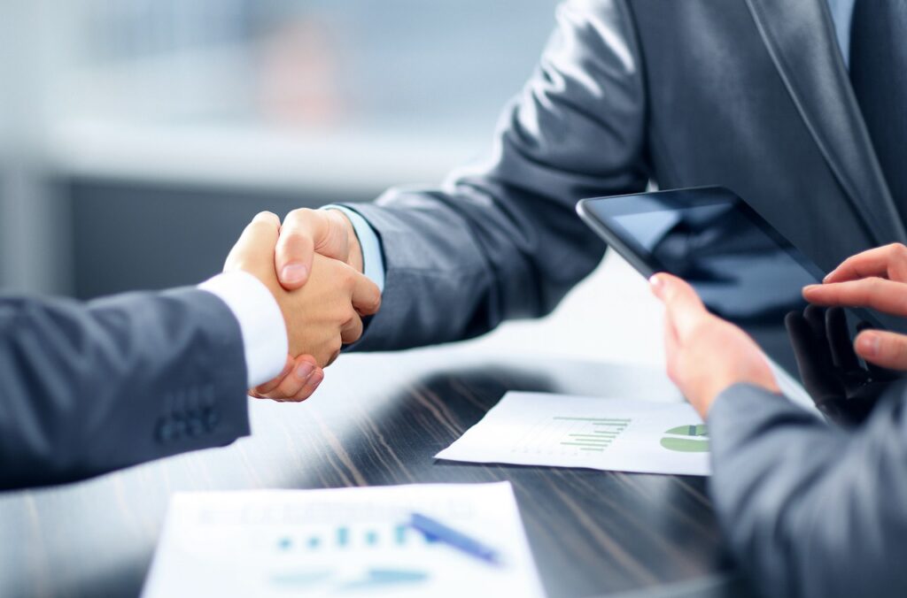 Prime and small business partners shaking hands on a teaming deal to reach an IDIQ contract