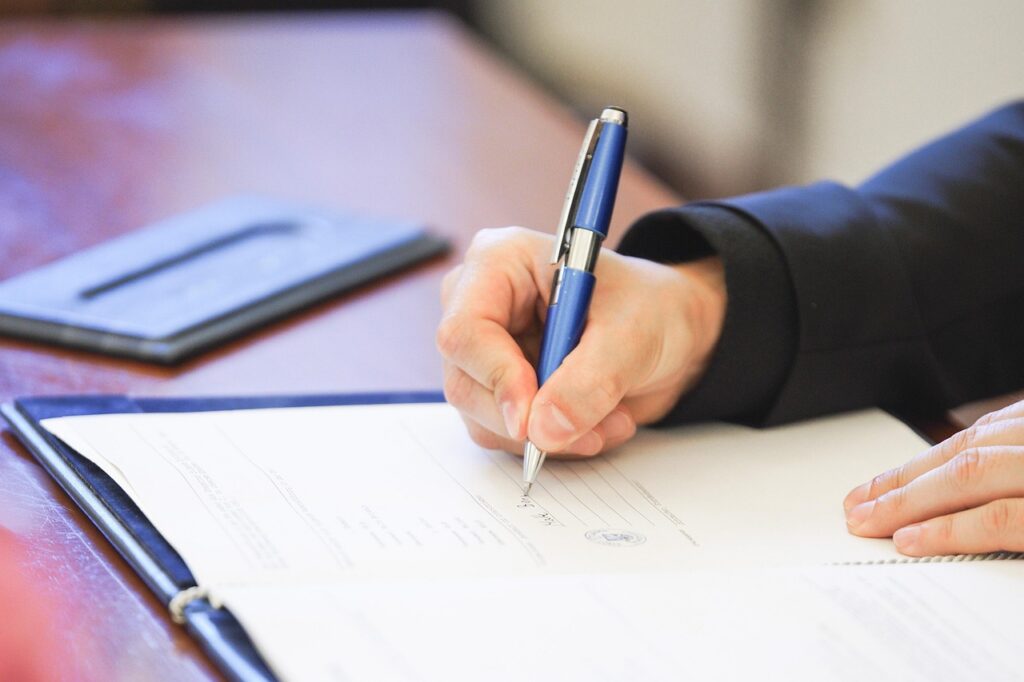 Business owner signing a supplier certification application
